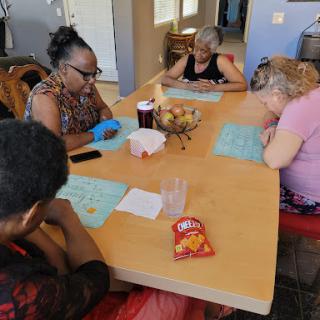 A group of individuals enjoying a bingo game while sharing snacks.