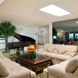 A luxurious living room featuring a grand piano, comfortable sofas, and elegant decor.