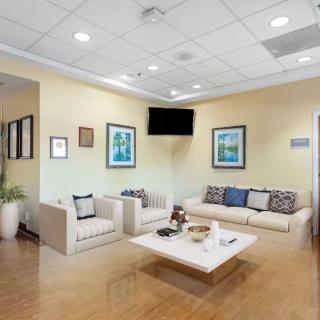 A modern waiting room with comfortable seating and contemporary artwork on the walls.