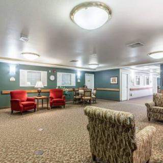A cozy lobby area with upholstered chairs, a table, and overhead lighting.