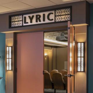 Entrance to a vintage-style theater named 'Lyric' with art deco design elements.