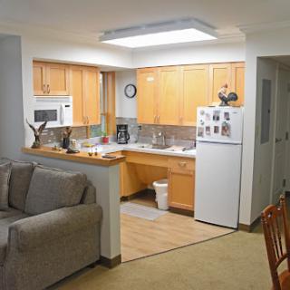 A cozy apartment featuring a combined kitchen and living space with modern appliances and comfortable seating.
