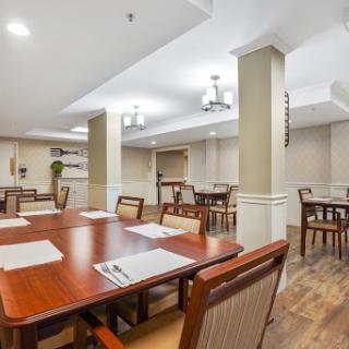 A spacious and modern dining area featuring wooden furniture and ample lighting.