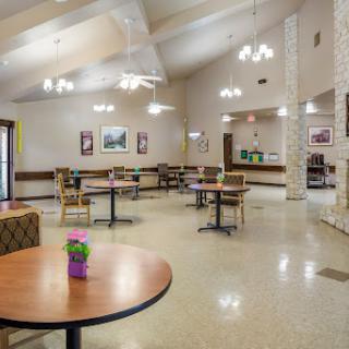 A spacious dining area featuring tables and chairs, illuminated by stylish light fixtures.