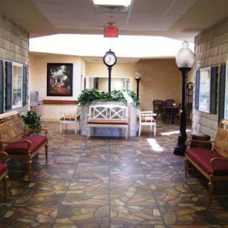 A spacious and inviting hallway with benches, a clock, and natural light.