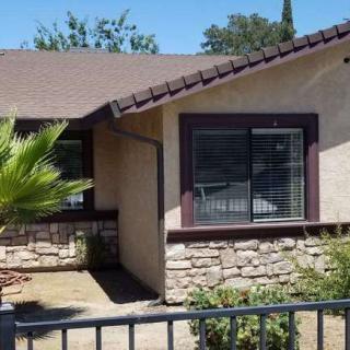 A single-story house with a sloped roof and stone wall accents.