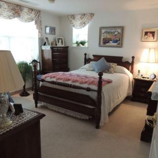 A cozy, traditionally styled bedroom with a large bed and elegant furnishings.