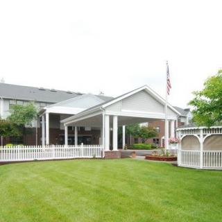 A building entrance with a well-maintained lawn and gazebo.
