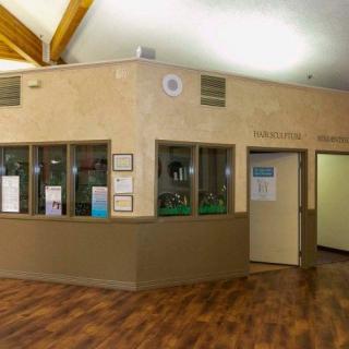 An interior view of an office reception area with wooden flooring and a corner desk.