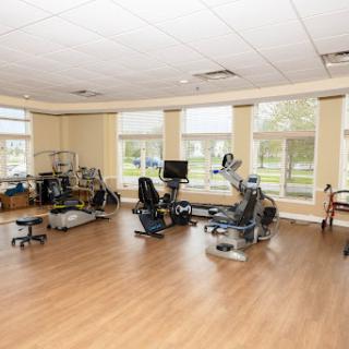 A spacious and well-lit fitness area equipped with various exercise machines.