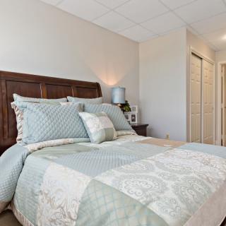 A cozy bedroom with a neatly made bed and soft lighting.