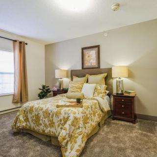 A cozy, well-decorated bedroom with warm lighting and elegant furnishings.