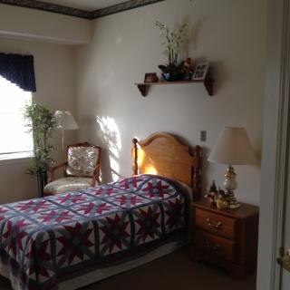 Cozy bedroom with a single bed, quilt, and natural light streaming through the window.