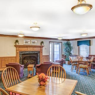 A cozy living and dining area featuring a fireplace, wooden furniture, and warm lighting.