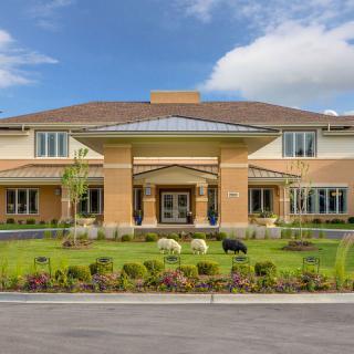 A large two-story house with well-maintained landscaping and a clear blue sky.