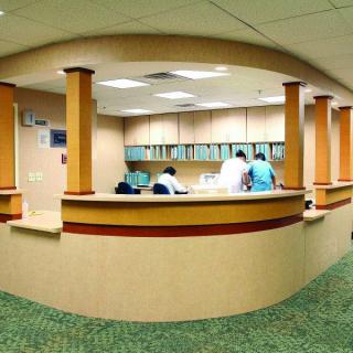 A hospital reception area with staff working at the desk.