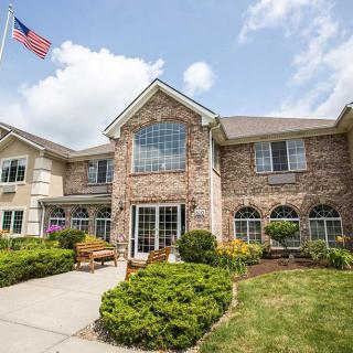 A two-story brick building with well-maintained landscaping and an American flag on display.