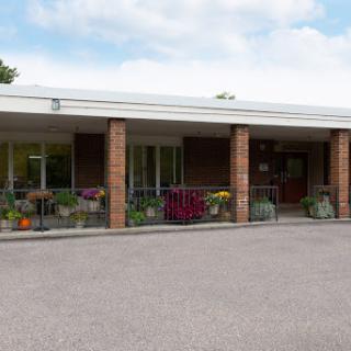 A welcoming exterior view of a school building with decorative plants.