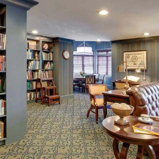 A cozy library interior with bookshelves, comfortable seating, and warm lighting.