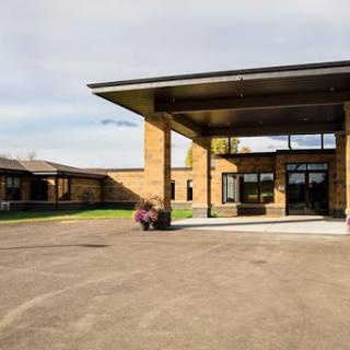 A modern architectural building with a spacious entrance and landscaped surroundings.