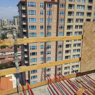 View from a construction site showcasing nearby high-rise buildings and scaffolding.