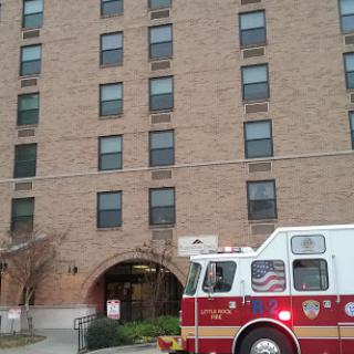A fire truck parked in front of a multi-story residential building.