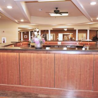 Spacious and welcoming reception area with wooden desk and ceiling lights.