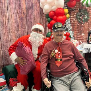 A festive moment captured with Santa Claus and an elderly gentleman enjoying the holiday spirit together.