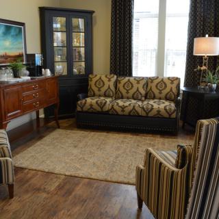A cozy living room with patterned furniture and warm lighting.