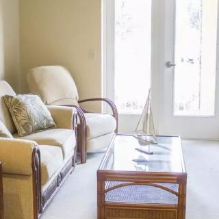 A cozy living room with a sofa, chair, and coffee table near a bright window.
