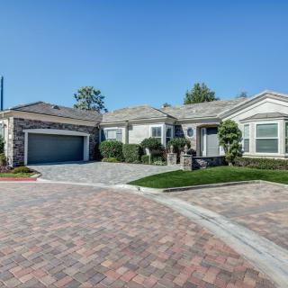 A suburban house with a driveway and garage, surrounded by neat landscaping.