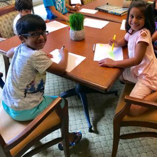Two children engaged in a creative activity at a table.