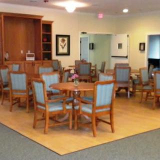 A cozy dining area with wooden tables and chairs, arranged in a spacious room.