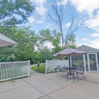A serene outdoor patio with tables, umbrellas, and lush greenery.