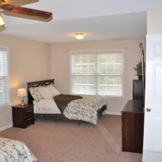 A cozy bedroom with two beds and ample natural light.