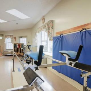 A therapy room equipped with various exercise machines and rehabilitation equipment.