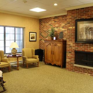 A cozy living room featuring a brick wall, comfortable seating, and a warm fireplace.