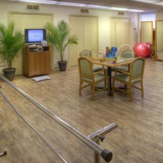 A rehabilitation room featuring exercise equipment and parallel bars for physical therapy.