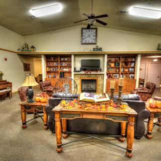 A cozy living room with a fireplace, shelves, and comfortable seating.