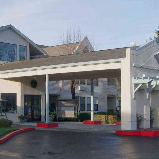 A residential building with a covered entrance and landscaped surroundings.