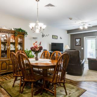 A cozy dining room with wooden furniture, a chandelier, and homey decor.