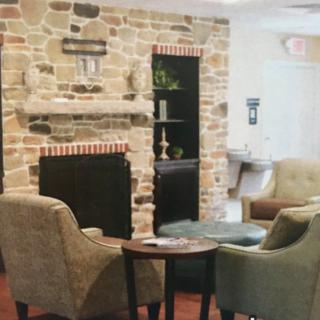 A cozy living room with a stone fireplace and comfortable armchairs.