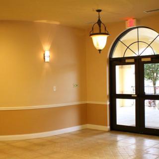 A warmly lit interior entrance with an arched doorway and tile floor.