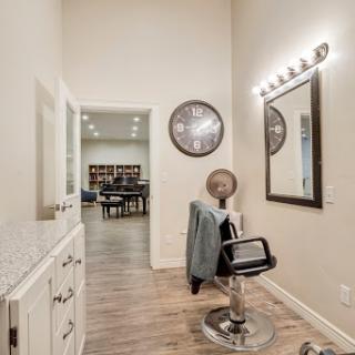 A stylish and modern salon space featuring a barber chair and well-placed lighting.