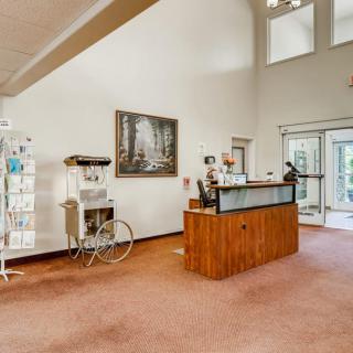 A spacious lobby with a reception desk and natural lighting.