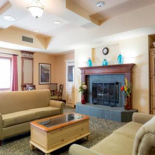 A cozy living room featuring a fireplace, two sofas, and a wooden coffee table.