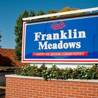 Welcome sign for Franklin Meadows, part of American Senior Communities.