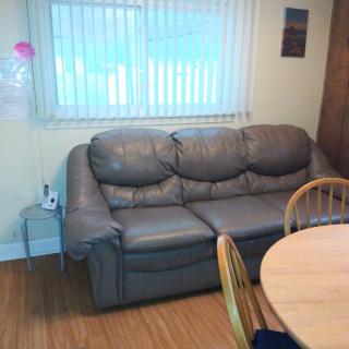 A cozy living room with a gray sofa next to a dining area.