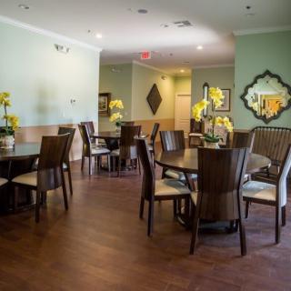 A cozy dining area with neatly arranged tables and chairs, featuring elegant decor and soft lighting.