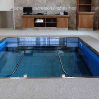 An indoor therapy pool equipped for rehabilitation exercises.